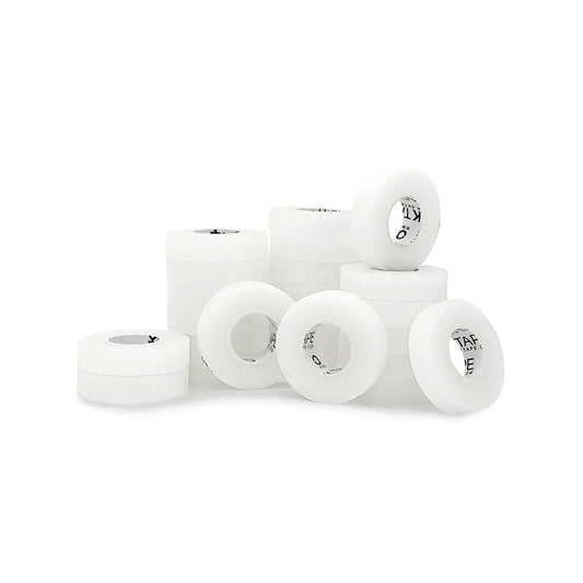 White skateboard wheels, evoking the look of large rolls of Transpore Tape by MedPharma USA, are displayed on a white surface. The arrangement features wheels both upright and flat, revealing black text inside.